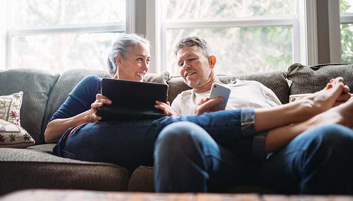 A middle-aged couple sitting on a couch and having a conversation